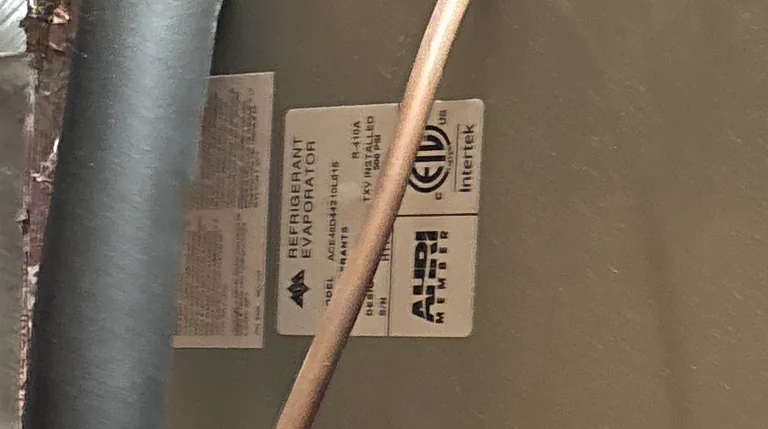 The data plate on the Folsom evaporator coil cabinet, reading REFRIGERANT EVAPORATOR, R-410A, TXV installed and a 500 PSI design pressure, with the Intertek ETL and AHRI certification marks