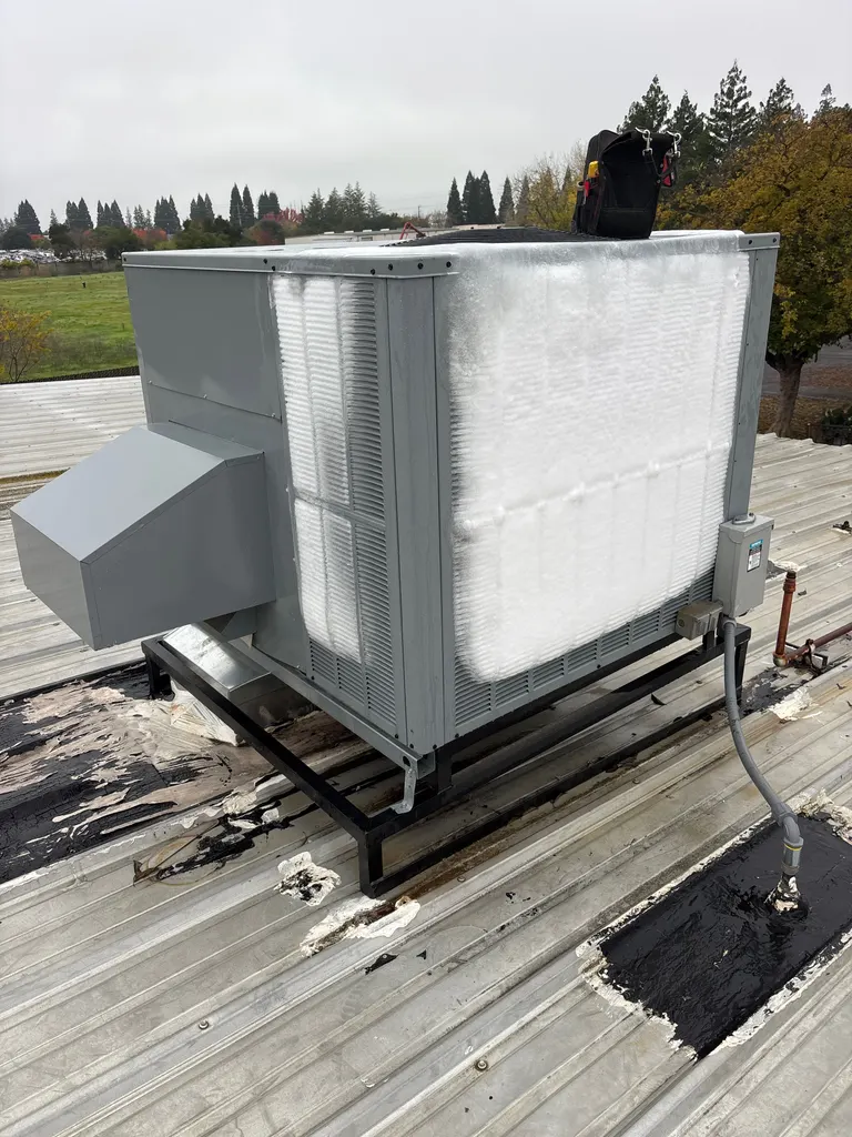 Rooftop heat pump unit encased in ice on a Sacramento-area service call, its entire coil face frozen solid white