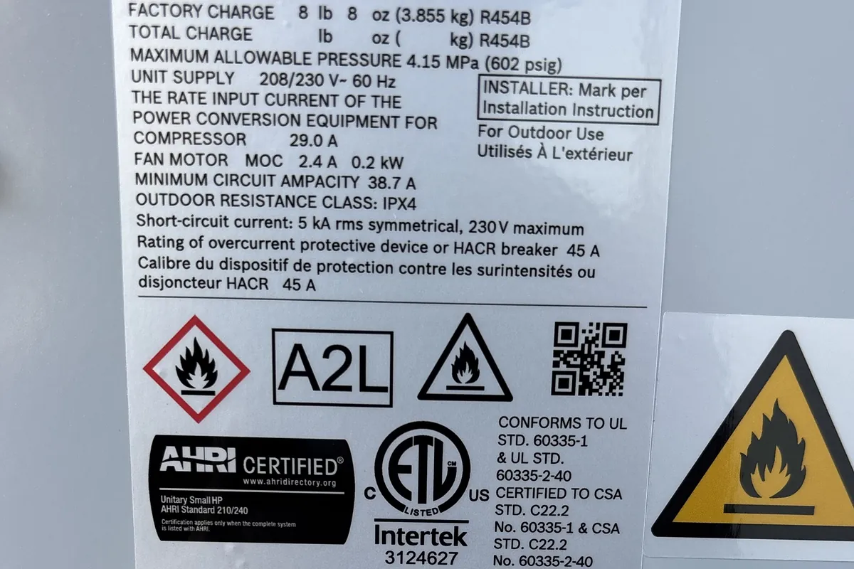The Bosch heat pump condenser nameplate showing a factory charge of 8 pounds 8 ounces of R-454B, the A2L refrigerant class mark, and flammable refrigerant warning symbols