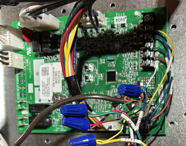 Air handler control board from one of our service calls, with the low-voltage blade fuse at the upper left and the thermostat terminal strip with the R, G and W wires landed on the right