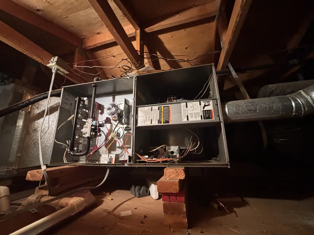 A gas furnace in a Folsom attic with both service panels removed, showing the gas valve, inducer and control board