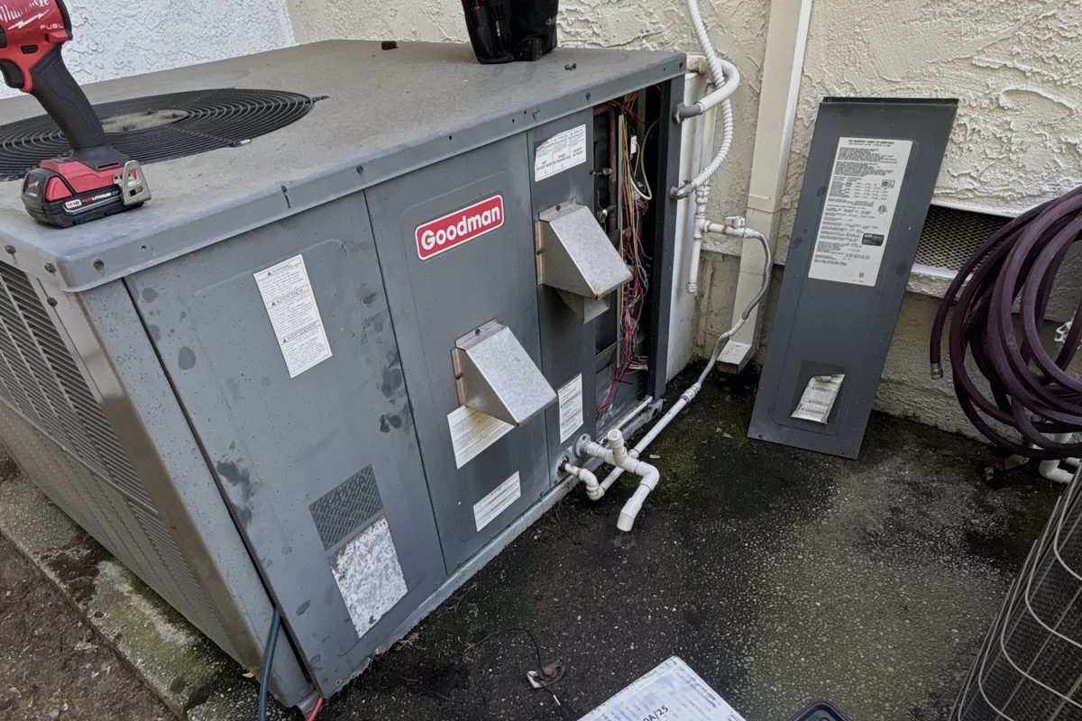 Goodman packaged AC unit with its access panel open during an HVAC repair at a Sacramento-area home