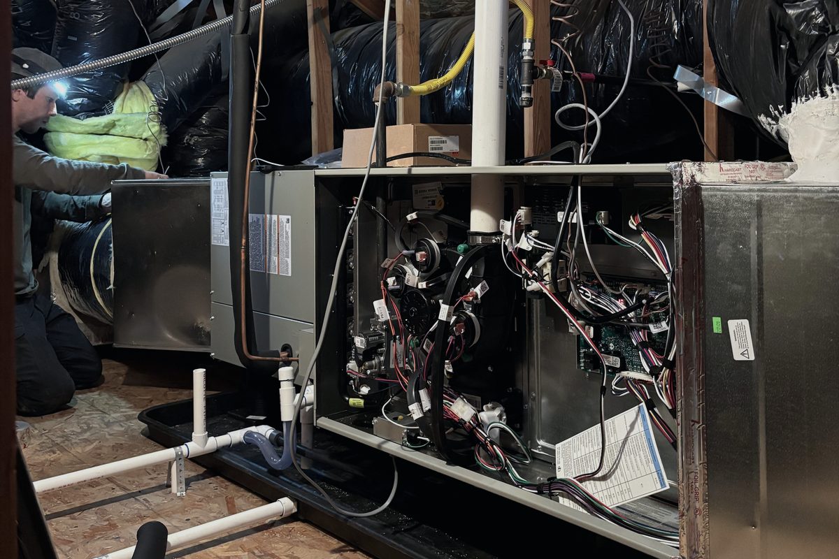 Alpha Mechanical technician installing a new gas furnace system in a Sacramento-area attic