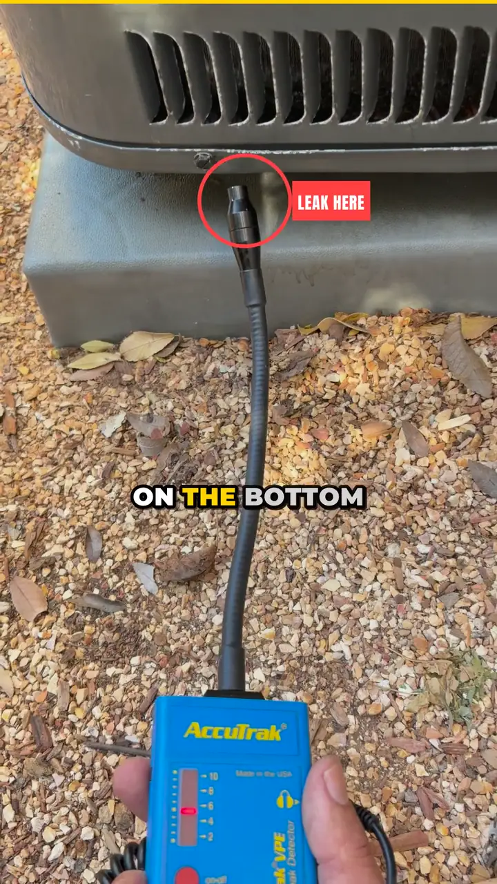 Video still: an ultrasonic leak detector in hand, its probe at the bottom of an outdoor AC coil marked Leak here