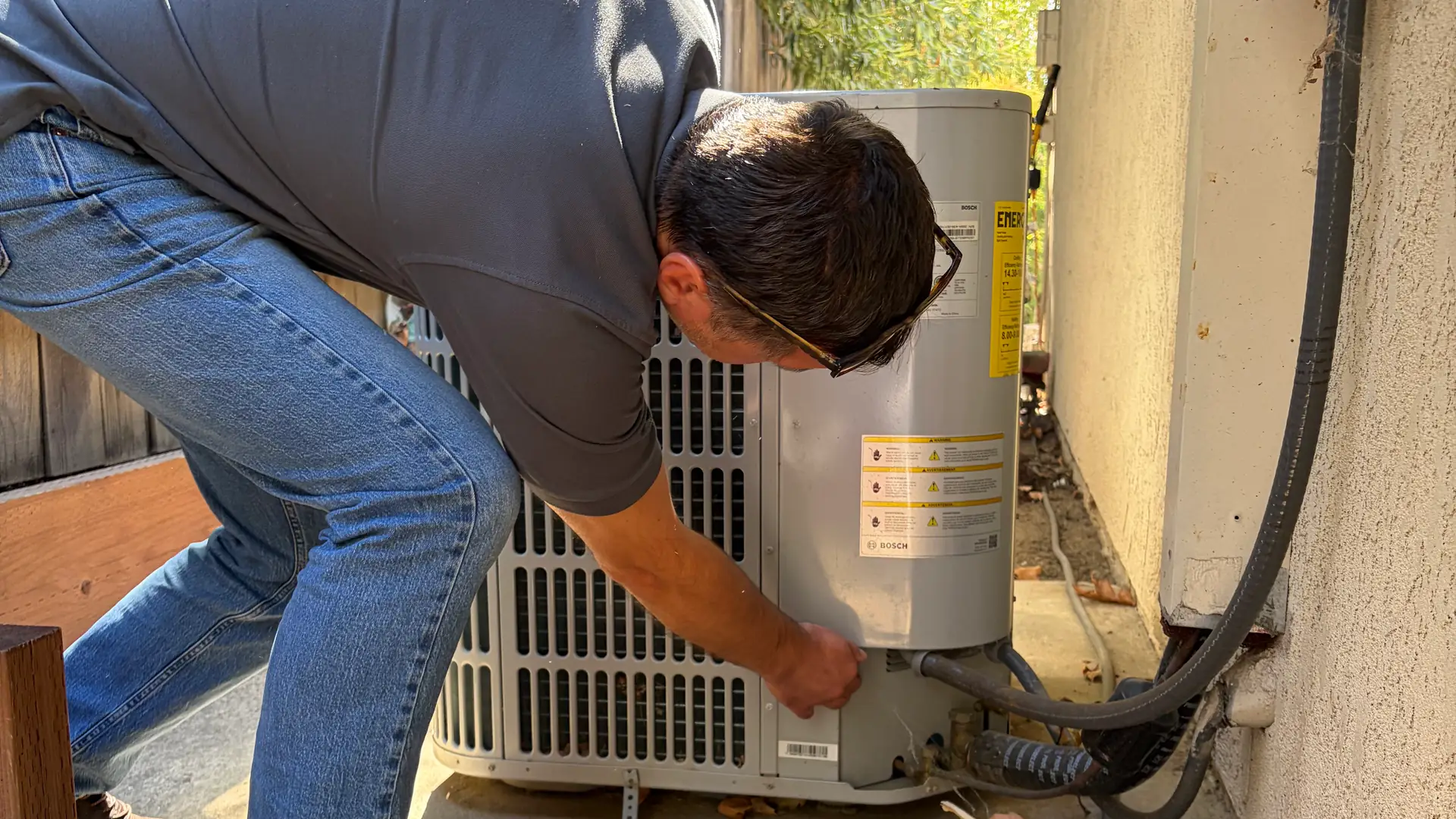 Alpha Mechanical technician working on an outdoor AC unit at a Sacramento-area home