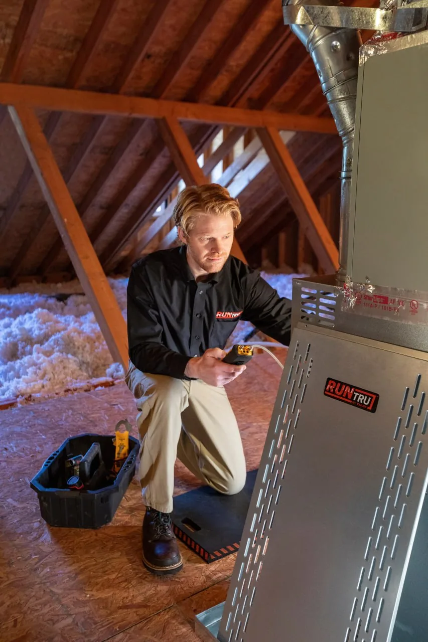 Alpha Mechanical technician performing a furnace tune-up on an attic gas furnace