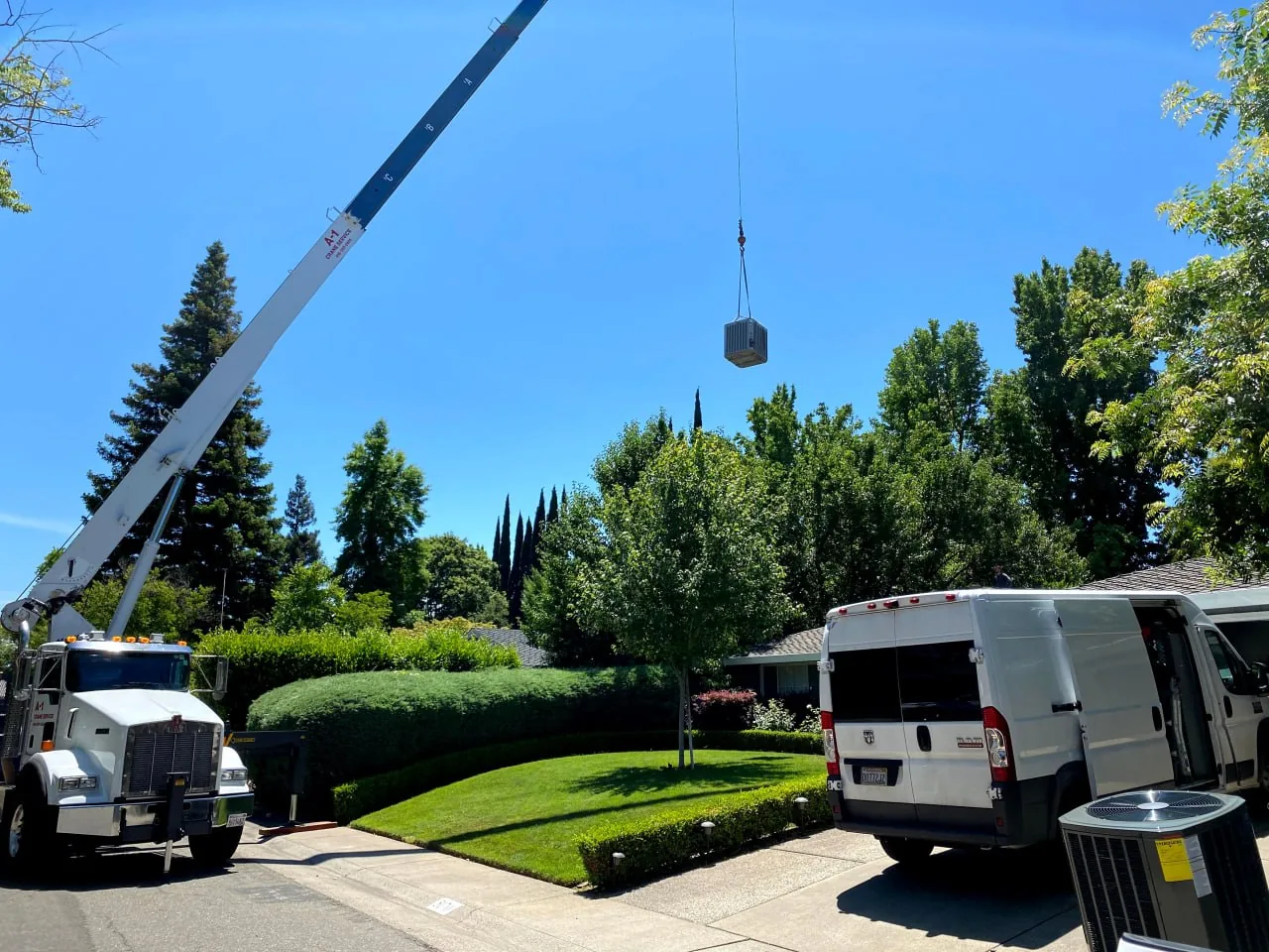 Crane lifting a new condenser onto a Sacramento home during an Alpha Mechanical heat pump replacement