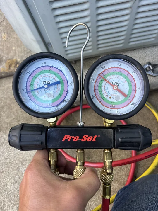 Pro-Set manifold gauge set connected to a residential AC, the dial face printed with R-22, R-410A, R-134a and R-404A pressure scales