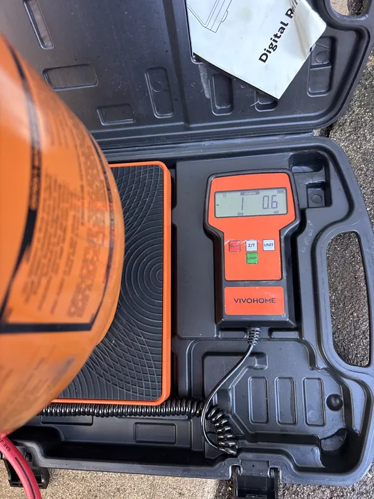 Digital refrigerant charging scale weighing a refrigerant cylinder by the pound to charge an AC system to its exact spec